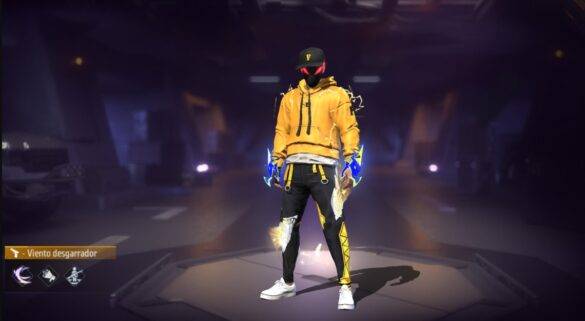 Imagen de un personaje en Free Fire vistiendo el traje "Viento Desgarrador", compuesto por una sudadera amarilla con acentos en negro y azul eléctrico, pantalones negros con detalles amarillos, y una gorra negra con el logotipo "F"